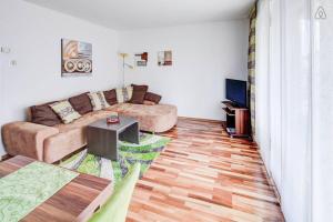 ein Wohnzimmer mit einem Sofa und einem Tisch in der Unterkunft Ferienwohnung in Augsburg in Augsburg