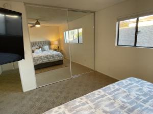 1 dormitorio con cama y espejo grande en LuxKing2bd2cargarageInstntHotwaterDesignerCarpet, en San Pedro