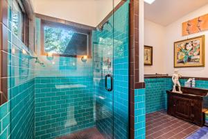 bagno con piastrelle blu e doccia in vetro di Selby Knoll Main House a Harrison