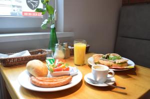 a table with two plates of breakfast foods and drinks at Cracow Central Aparthotel in Krakow