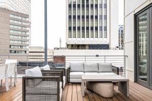 a balcony with a couch and tables on a building at Rooftop Condo in Nashville