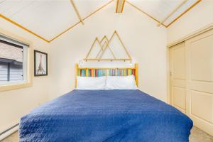ein Schlafzimmer mit einem blauen Bett und einem Fenster in der Unterkunft Mountainside Condo #307 in Girdwood