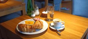 einen Tisch mit einem Teller Essen und einer Tasse Kaffee in der Unterkunft Cracow Central Aparthotel in Krakau