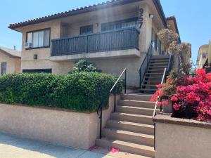 una casa con escaleras y flores delante en LuxKing2bd2cargarageInstntHotwaterDesignerCarpet, en San Pedro