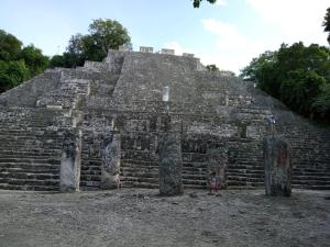 a child stands in front of the pyramid at cabañas kukulkan in Xpujil +4 photos