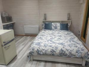 a bedroom with a bed with blue and white sheets at Delightful log cabin with views of Scrabo tower in Comber