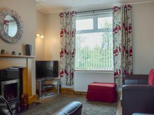 a living room with a tv and a window at Parkview in Skipton