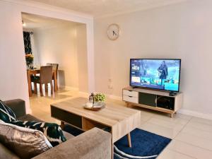 a living room with a couch and a tv at Delight Marvel- Beech Hurst-3 bedroom house in Maidstone