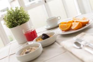 un tavolo con piatti di cibo e una ciotola di fette d'arancia di Hotel Stockholm a Rimini