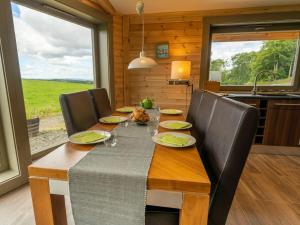 een eetkamer met een tafel en stoelen en een keuken bij Alban in Linlithgow