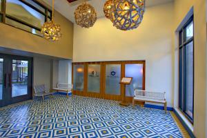 un vestíbulo con 2 bancos y 2 lámparas de araña en La Pinta Hotel en Ensenada