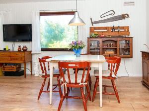 a kitchen with a table with chairs and a tv at 6 person holiday home in Ørsted-By Traum in Ørsted