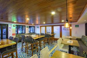 a restaurant with wooden ceilings and tables and chairs at La Pinta Hotel in Ensenada