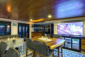 a dining room with a table and chairs and a tv at La Pinta Hotel in Ensenada