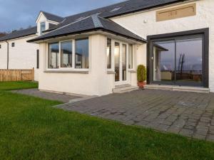 a white house with a large sliding glass door at Sunset View in Ardmaleish