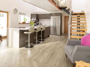 a kitchen and living room with a staircase in a house at Sunset View in Ardmaleish