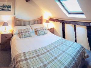 a bedroom with a bed with two pillows and a window at Jinney Ring in Leintwardine