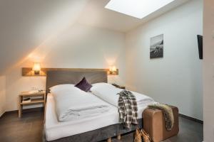 sypialnia z łóżkiem z białą pościelą w obiekcie AlpenParks Hotel & Apartment Central Zell am See w mieście Zell am See
