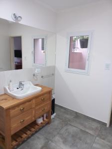 uma casa de banho com um lavatório e um espelho em La Casita del Arrayan en Tandil em Tandil