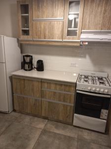a kitchen with a stove and a refrigerator at La Casita del Arrayan en Tandil in Tandil