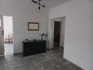 a living room with a black dresser in a room at La Casita del Arrayan en Tandil in Tandil