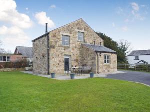 a stone house with a table and chairs in front of it at Five Barred Gate Barn in Inglewhite