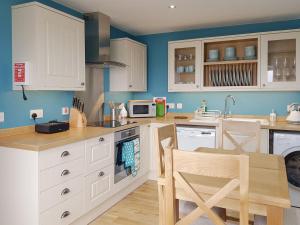 a kitchen with white cabinets and a table and chairs at Ethels House in Armadale