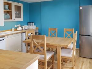 a kitchen with a wooden table and chairs at Ethels House in Armadale