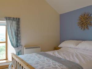 a bedroom with a bed and a window at The Smithy - Ukc3748 in Charmouth