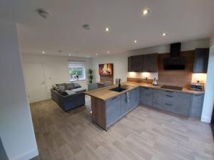 a large kitchen and living room with a couch at Luxury home away from home in Manchester