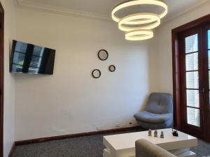 a living room with a chair and a table and a chandelier at Departamento 6 personas Plaza San Martin in Buenos Aires