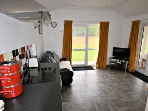 a living room with a couch and a tv at Orchard Farm Cottage in Barnby