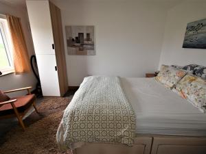 een slaapkamer met een bed, een stoel en een raam bij Orchard Farm Cottage in Barnby