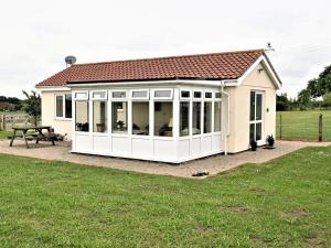 a large white conservatory with a picnic table at Orchard Farm Cottage in Barnby
