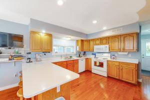 a large kitchen with wooden cabinets and white appliances at Bar Harbor Oasis in Bar Harbor