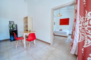 a living room with a table and two red chairs at Villa Casa Azul & Arena Blanca Apartamentos in Puerto Viejo