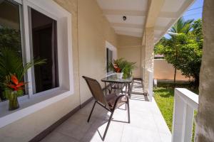 patio ze stołem i krzesłami na balkonie w obiekcie Villa Casa Azul & Arena Blanca Apartamentos w mieście Puerto Viejo