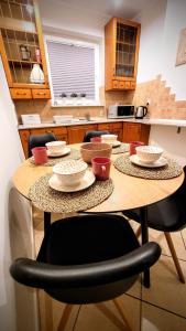 a table with bowls and plates on it in a kitchen at Apartament DANA piękna plaża wydmy las in Ustka
