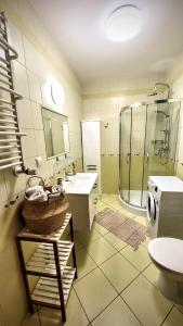 a bathroom with a sink and a shower and a washing machine at Apartament DANA piękna plaża wydmy las in Ustka