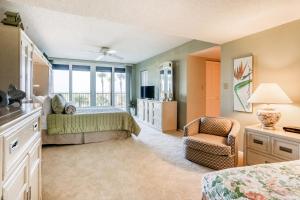a bedroom with a bed and a chair and a window at Landmark Towers 203 in Clearwater Beach