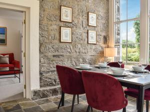 una sala da pranzo con tavolo e sedie rosse di Castle View - Ukc5701 a Castletown