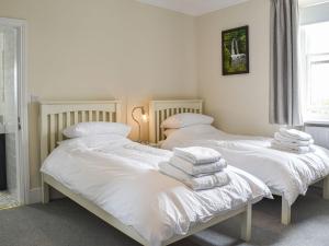 2 camas en una habitación con sábanas y almohadas blancas en Castle View - Ukc5701, en Castletown