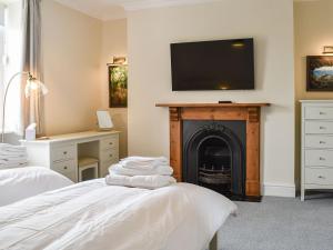 a bedroom with two beds and a fireplace with a flat screen tv at Castle View - Ukc5701 in Castletown