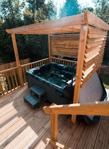 bañera de hidromasaje en una terraza de madera en Luxury Renovated Bungalow with wheel chair access, Hot Tub and Fire Pit, 
