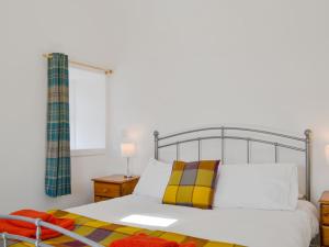 - une chambre dotée d'un lit blanc avec un cadre métallique dans l'établissement Wester Laggan Cottage, à Skye of Curr