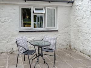 2 Stühle und ein Tisch vor einem Fenster in der Unterkunft Barnhill Bothy in Moffat