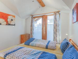1 dormitorio con 2 camas y ventana en Penthouse Petra, en Brixen im Thale