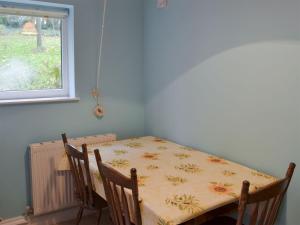 mesa de comedor y sillas con mesa y ventana en Lukesland Farm en Harford