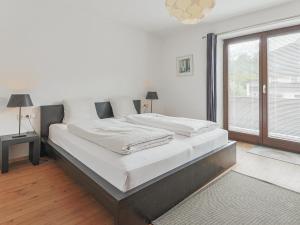 a large bed in a room with a large window at Berg und Bach in Kirchberg in Tirol