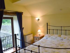 een slaapkamer met een bed en een raam bij Spring Cottage in Hollinsclough